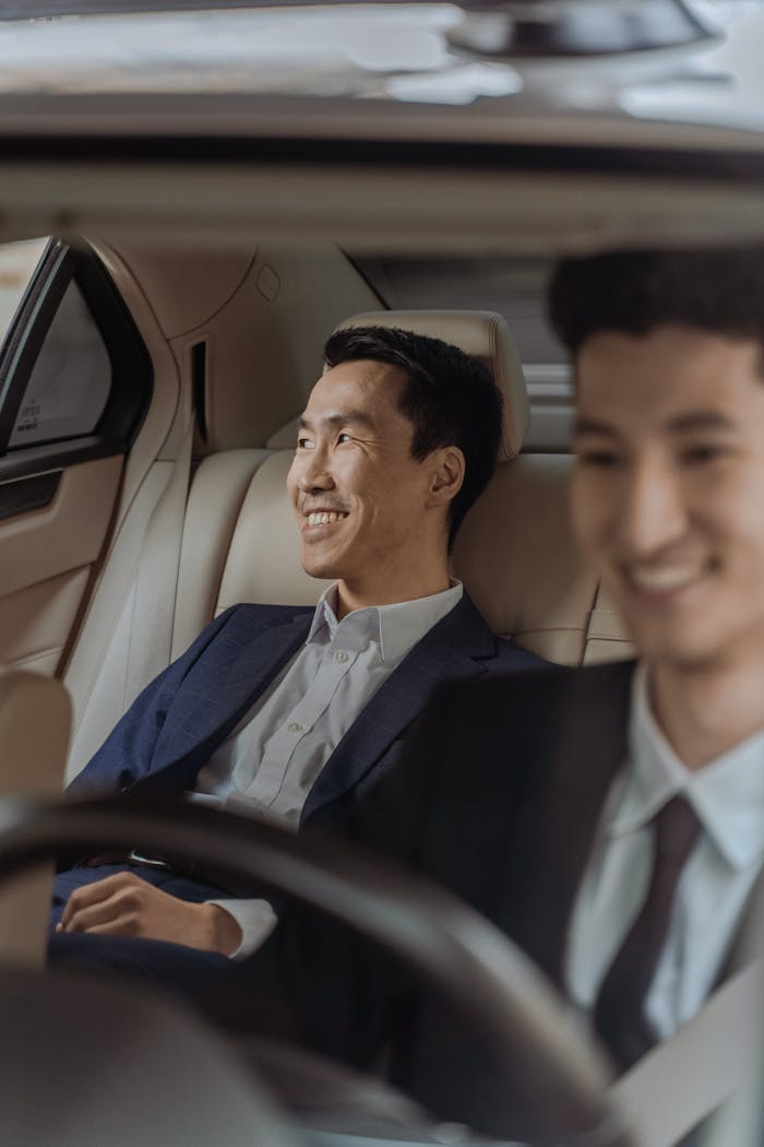 Crafting Captivating Headlines: Your awesome post title goes here Two men in formalwear enjoying a comfortable ride in a luxury car, smiling.